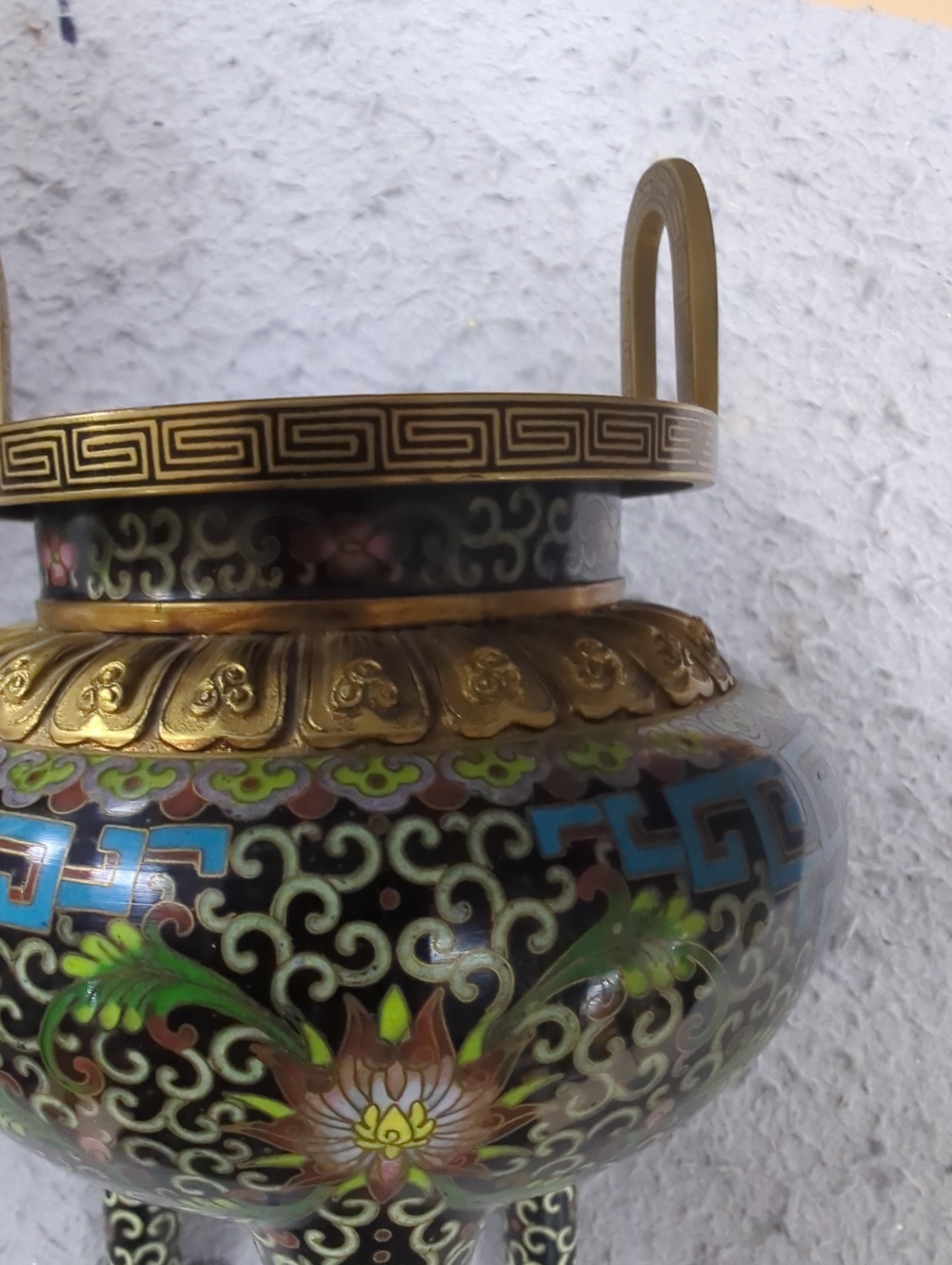 A Chinese cloisonné enamel three footed vase and cover together with a censer and cover, each raised on hardwood stands, the largest 26cm in diameter